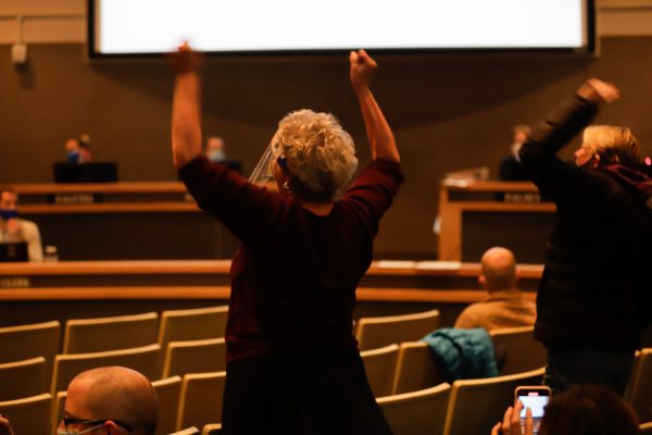 People clap at the Anchorage Assembly meeting.