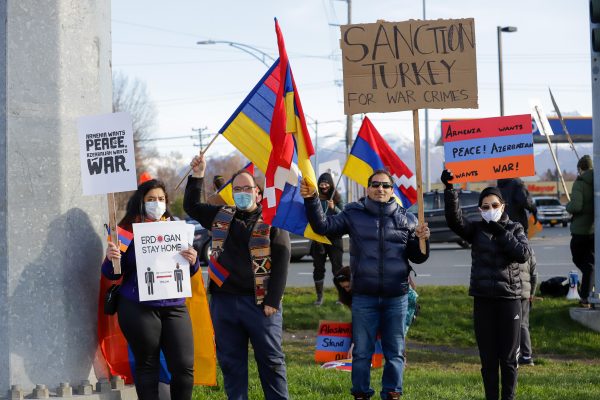 a small group of people at a rally holding signs