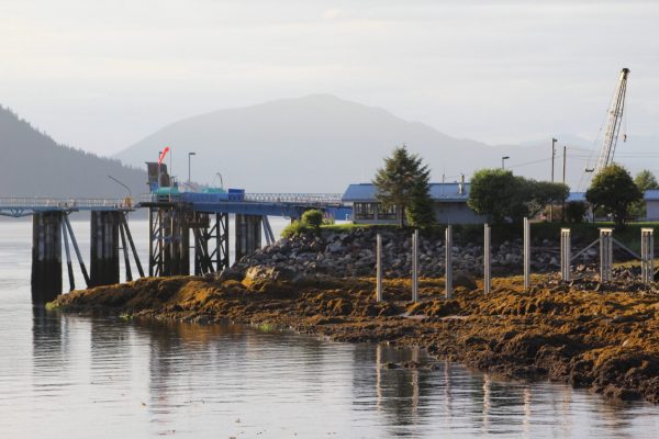 An empty ferry terminal on a foggy day with mountains in the background