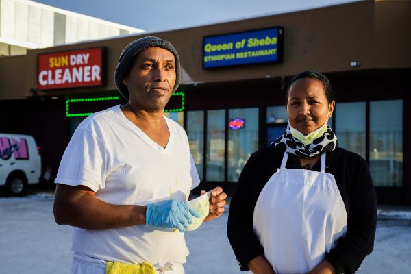 two people outside their restaurant