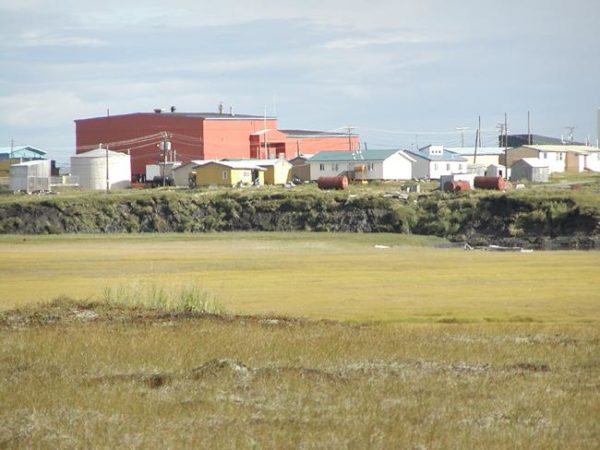 A green field and a red building