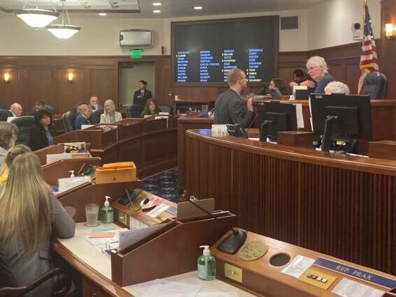 A hearing room with a bunch of people at their desks