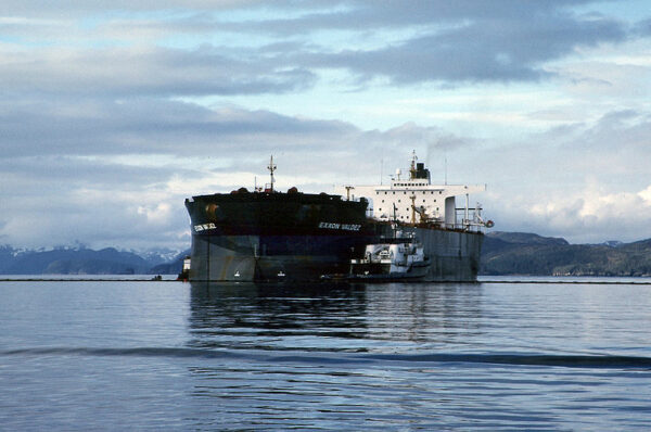 A large ship on the water with mountains in the background.