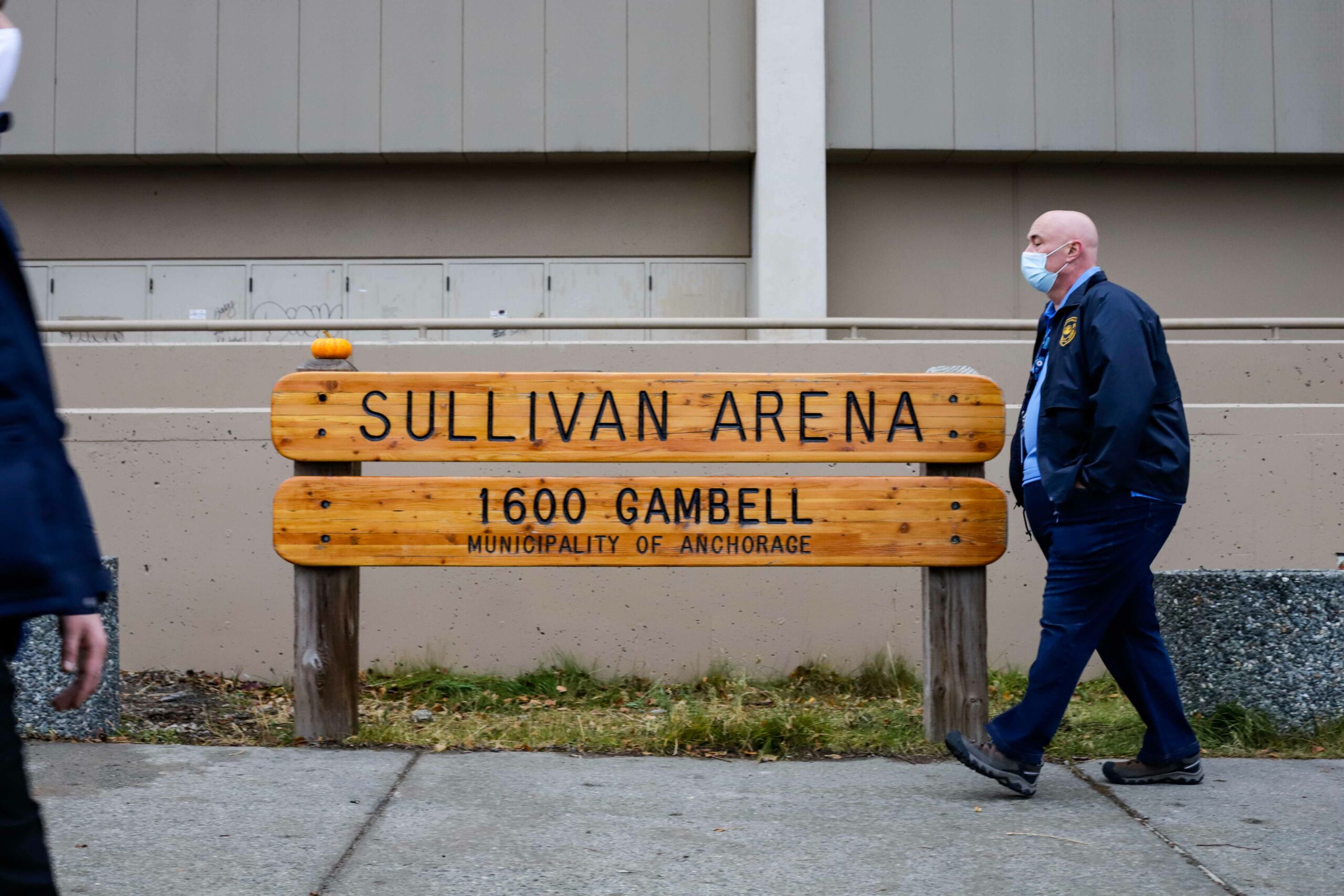 Joe Gerace walks by a sign in front of building that reads "Sullivan Arena"