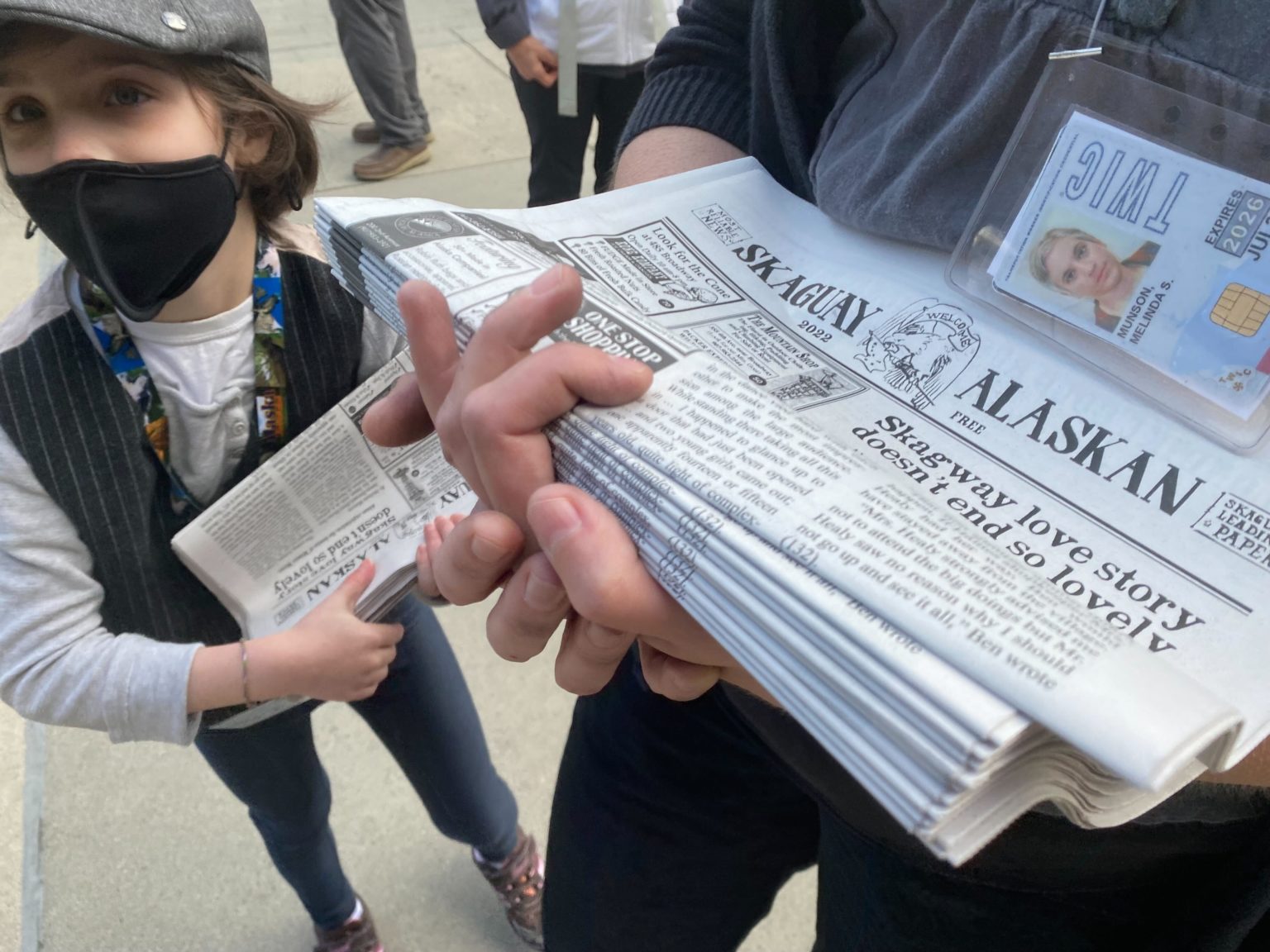 two people hold Skagway newspapers